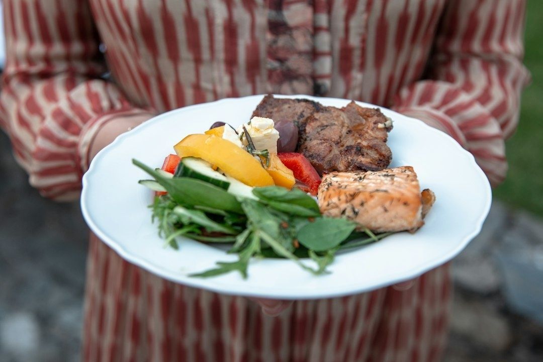 Tallerken med grønt, grøntsager, laks og en grillet bøf